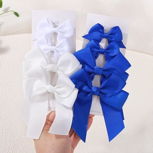 Detail of white and royal blue grosgrain ribbon hair bow clips on display cards