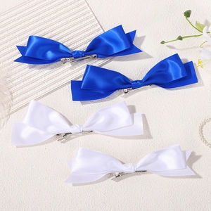 Detailed macro view of four satin bow hair clips in blue and white colors