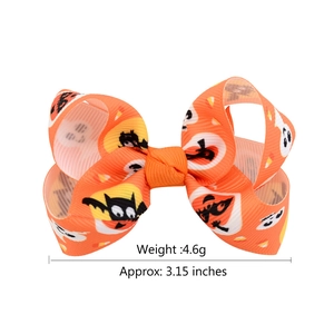 Detail view of 3.15 inch orange Halloween bow clip showing ghost and bat patterns