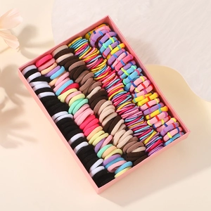 Vue détaillée d'élastiques à cheveux colorés rangés dans une boîte rose pour fille
