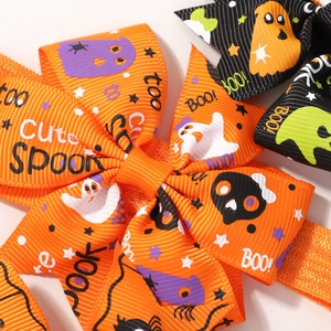 Close-up of Halloween hair bows with orange ribbon, spooky ghost and spider patterns