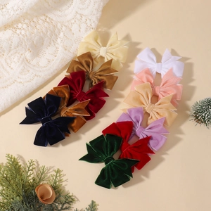 Dix barrettes à nœuds en velours coloré pour filles présentées avec un décor élégant