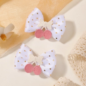 Détail des barrettes à cerises double épaisseur avec pois dorés et broderies fines