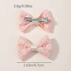 Handgemaakte roze haarstrikken met wit geborduurde bloemen en metalen eendenbekclips