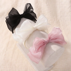 Nahaufnahme von fluffigen Organza-Haarbändern in Schwarz, Weiß und Rosa im Display