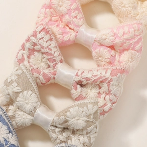 Detail van geborduurde bloemenstrik haarspeldjes in zachte pastelkleuren