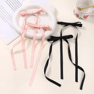 Set of four bow hair clips with long tassels in pink and black for women and girls