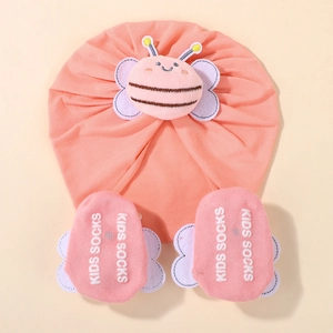 Detailed view of pink cotton baby turban hat and anti-slip socks with cute plush bee decor