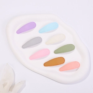 Close-up of eight colorful lace-trimmed drop hair clips on a white ceramic display tray