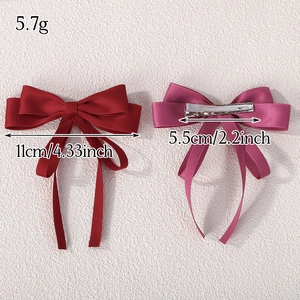 Set of two double-layered satin bow hair clips in red and purple with metal spring clips