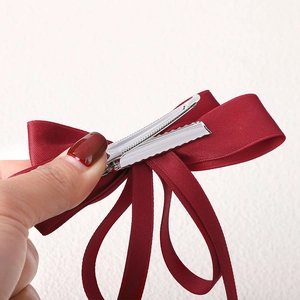 Close-up of the silver alligator clip on a red double-layered ribbon hair bow