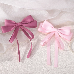 Detail of double-layered satin ribbon bows in pink with long flowing streamers