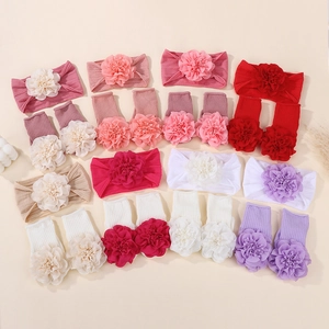 Detailed close-up of ribbed cotton baby headband and socks set with large floral accents