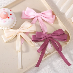 Three double-layer satin ribbon bow hair clips in pink, cream, and burgundy for girls