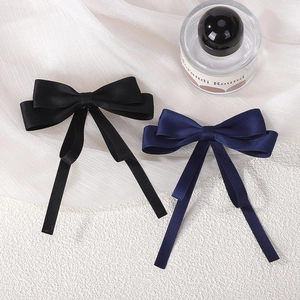 Detail of satin bow hair clips in black and navy blue with elegant long streamers