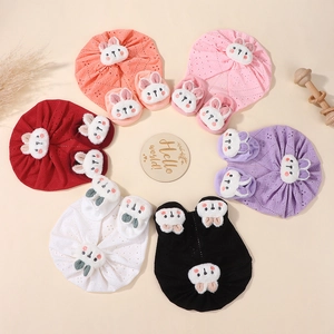 Flat lay of cotton infant hat and sock sets with cute plush bunny decor in six colors