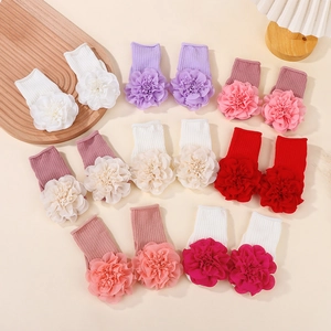 Detailed view of knitted baby socks with large chiffon floral accents in multiple colors
