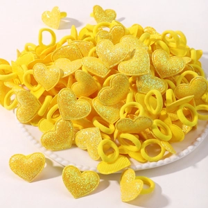 Détail macro d'élastiques à cheveux cœur jaunes avec finition pailletée dorée brillante