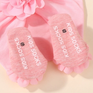 Primer plano de calcetines rosa para bebé con suela antideslizante y encaje de malla