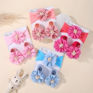 Flat lay of baby headband and sock sets with large fabric flowers in four pastel colors