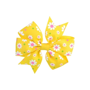 Detailed macro view of yellow ribbed ribbon hair bow with white daisy floral patterns
