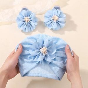 Detailed close-up of light blue baby turban with soft textured knit and 3D floral petals