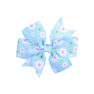 Detailed view of light blue hair bow with daisy prints and polka dots on grosgrain ribbon