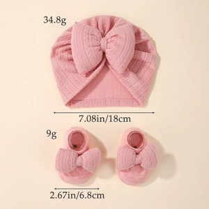 Pink newborn baby knit hat and socks set with large bows and ribbed cotton texture