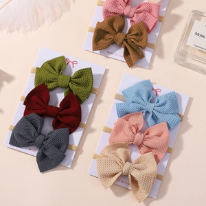 Detailed view of eight assorted waffle fabric baby bows on high-stretch nylon headbands