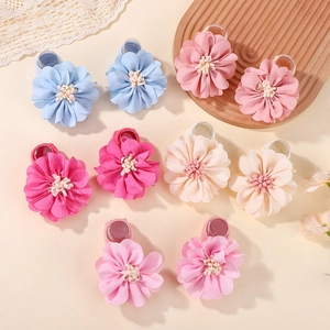 Detail of five pairs of handmade fabric flower hairbands for baby girls in soft colors