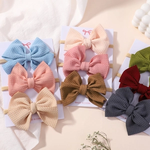 Detailed view of waffle texture fabric bows on elastic nylon baby headbands with cards