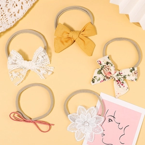 Detail view of 5-piece baby headband set with bows and lace flowers on nylon bands