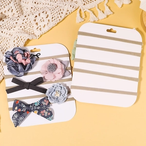 Detail of baby floral headbands and bows on display card with soft lace background