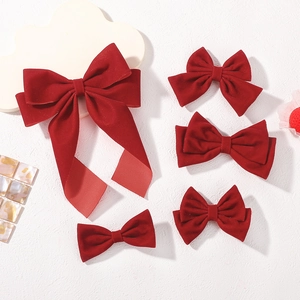Detailed set of five red velvet bow hair clips featuring long ribbons and varied styles