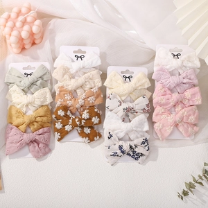Detail of four floral embroidery and lace bow hair clips for girls on display card