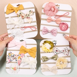 Detail of handmade bow headbands and fabric flowers set for babies on display cards