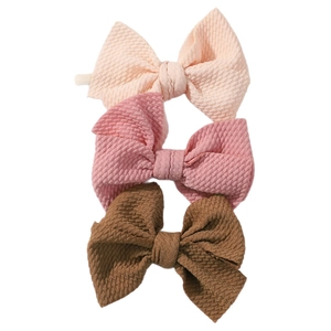 Three-piece set of textured bubble fabric bow nylon headbands for baby girls in neutral tones