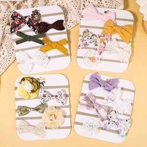 Close-up of handmade floral and lace bow headbands for infants in a premium 19-piece gift set