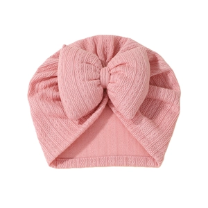 Pink newborn baby turban hat featuring a large soft bow and delicate knitted texture