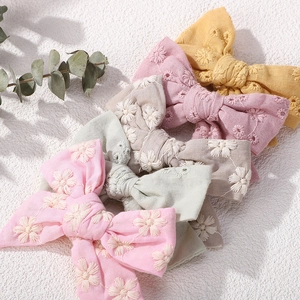 Close-up of embroidered floral patterns on cotton linen fabric hair bow clips for girls