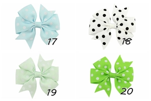 Macro shot of four dotted grosgrain ribbon hair bow clips in various pastel colors