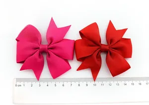 Detail showing two ribbon hair clips in rose and red with scale ruler measurement