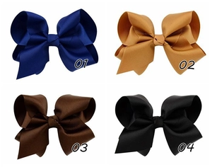 Detail of four large grosgrain ribbon hair bows in navy blue, yellow, coffee, and black