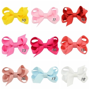 Detailed grid of grosgrain ribbon bow hair clips in nine assorted colors for kids