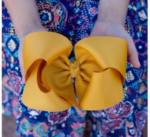 Macro detail of a large 8-inch yellow grosgrain ribbon hair bow for girls
