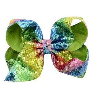 Detail of 8-inch rainbow sequin hair bow showing colorful gradient and glittering texture