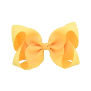 Grande fiocco per capelli in nastro grosgrain giallo limone per bambine su sfondo bianco