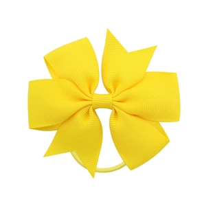 Detail of vibrant yellow grosgrain ribbon bow hair tie with textured ribbed surface