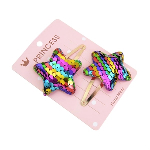 Detail of star-shaped hair clips for kids with gradient rainbow sequins and golden clips