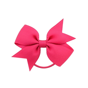 Détail du nœud en ruban gros-grain rose vif avec un élastique à cheveux durable